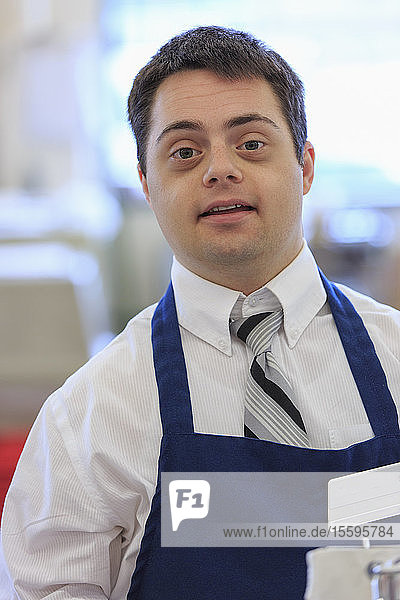 Porträt eines Mannes mit Down-Syndrom  der in einem Lebensmittelladen arbeitet