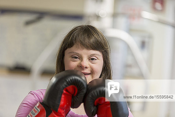 Portrait of a woman with Down Syndrome working out with boxing gloves