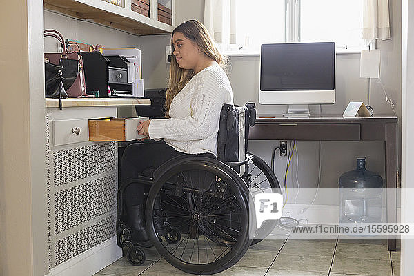 Woman with Spinal Cord Injury arranging things in her room