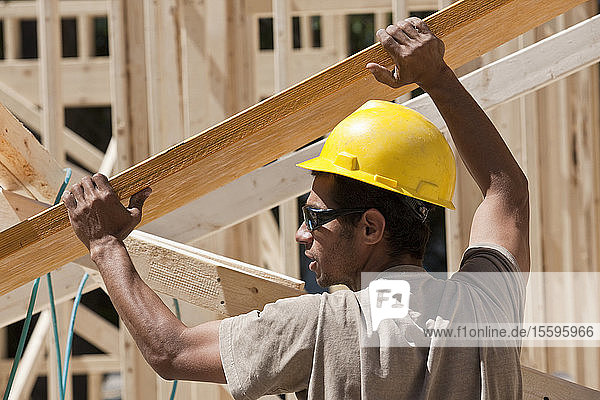 Zimmermann beim Anheben eines Leimbinders auf einer Baustelle