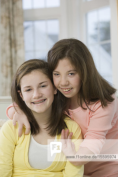 Zwei lächelnde Mädchen im Teenageralter  eines mit Geburtsfehler