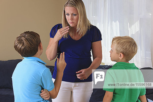 Mother and sons with hearing impairments signing in American sign language