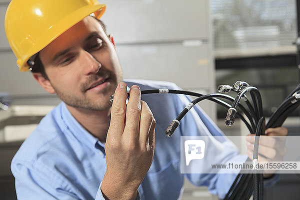 Network engineer examining cable termination connector