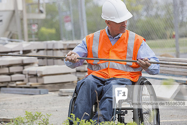 Projektingenieur mit einer Rückenmarksverletzung in einem Rollstuhl auf der Baustelle