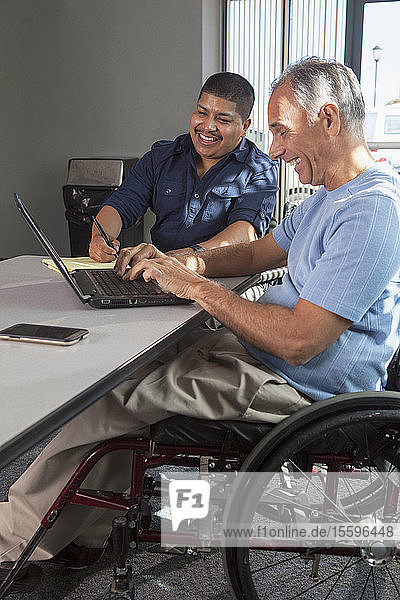 Two men with Spinal Cord Injuries working in an office