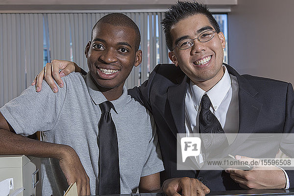 Happy portrait of two men with Autism smiling in an office