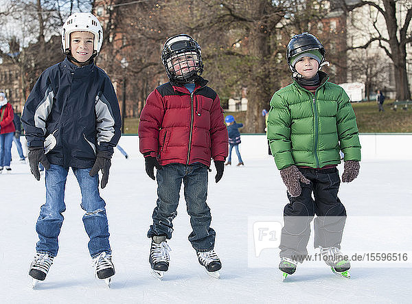 Drei Jungen in Eishockey-Schlittschuhen