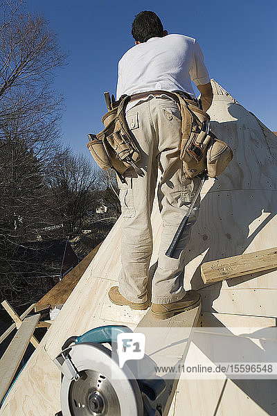 Zimmermann bei der Arbeit am Türmchen eines Hauses