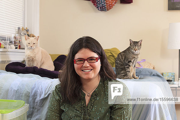 Frau mit Asperger-Syndrom spielt mit ihren Hauskatzen