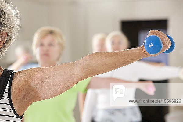 Seniors exercising with dumbbells in a health club