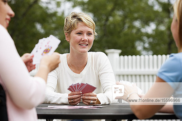 Blick auf drei Frauen beim Kartenspielen.