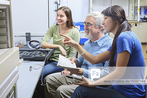 Professor bei der Arbeit mit Studenten in einem Chemielabor  die etwas über Messgeräte lernen (PH-Meter)