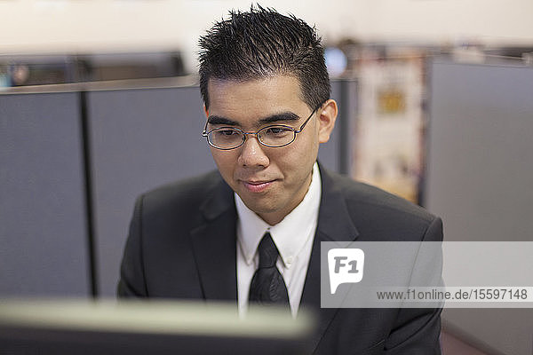 Asian man with Autism working on computer in an office