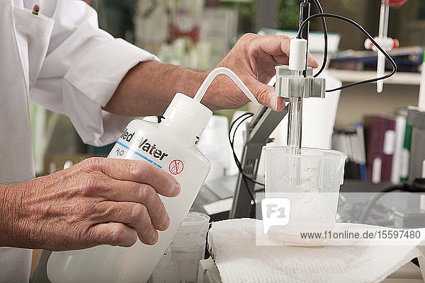 Wissenschaftler  der ein pH-Meter im Labor einer Wasseraufbereitungsanlage benutzt