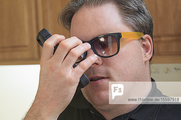 Man with congenital blindness using assistive listening to hear his text messages