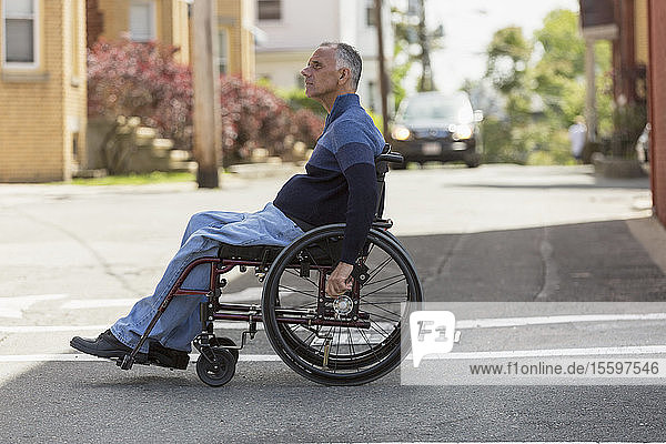 Man with Spinal Cord Injury crossing the road in his wheelchair