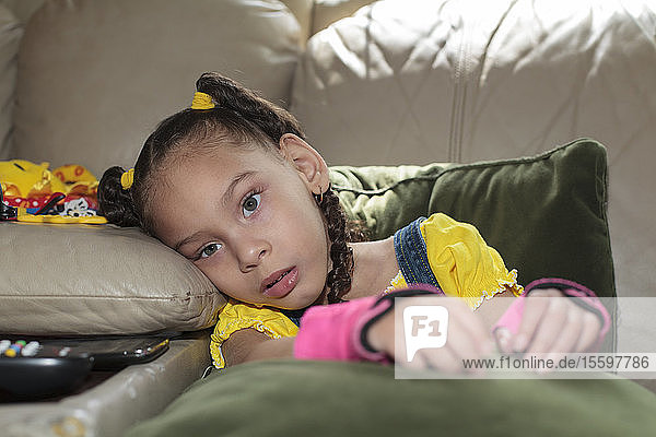Kleines Mädchen mit zerebraler Lähmung sitzt zu Hause