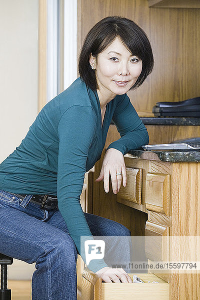 Porträt einer mittleren erwachsenen Frau  die in der Küche lächelt