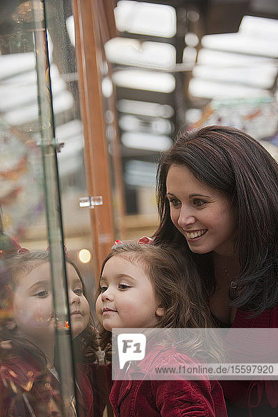 Frau beim Schaufensterbummel mit ihrer Tochter während der Feiertage auf dem Quincy Market