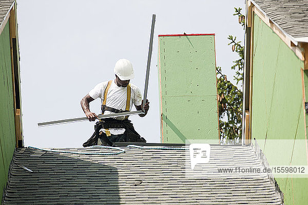 Dachdecker bei der Vorbereitung der Abdeckungen an der Spitze des Daches