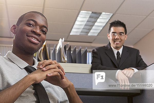 Portrait of two men with Autism smiling in an office