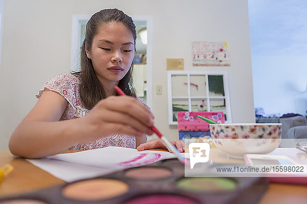 Teenager-Mädchen mit einer Lernbehinderung verwendet Farben