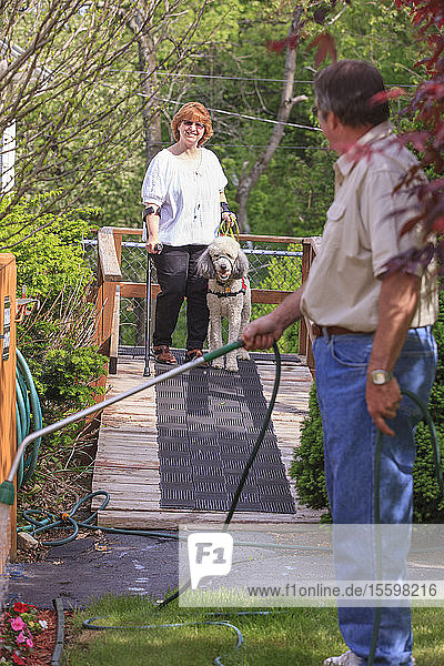 Frau mit RSD und ihr Diensthund gehen auf ihrer Rollstuhlrampe spazieren