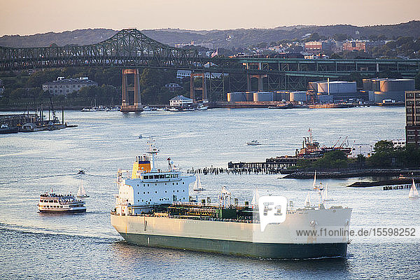 Ship and boats in a river with a bridge in the background  Tobin Bridge  Chelsea  Boston  Massachusetts  USA