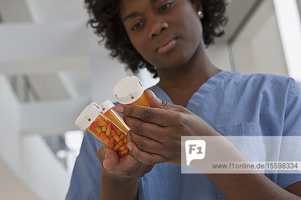 Jamaican female nurse checking pill bottles