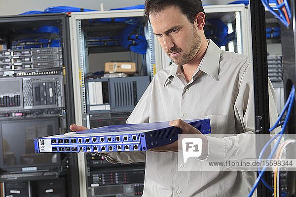 Network engineer examining switch in data center