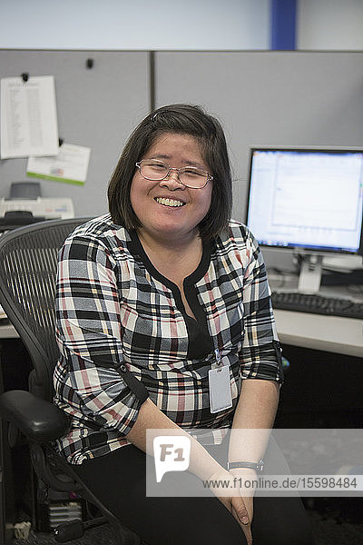 Porträt einer glücklichen asiatischen Frau mit einer Lernbehinderung  die im Büro lächelt
