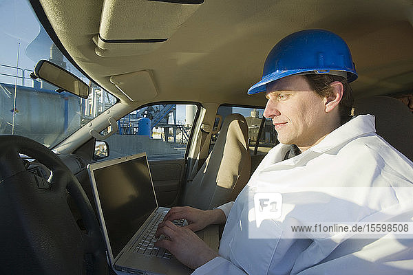 Engineer working on a laptop in a car