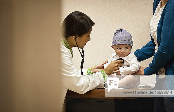 Doctor listening to baby boy's chest with stethoscope