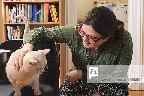 Frau mit Asperger-Syndrom spielt zu Hause mit ihrer Hauskatze