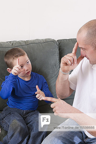 Mann gebärdet das Wort Brother in amerikanischer Zeichensprache  während er mit seinem Sohn kommuniziert