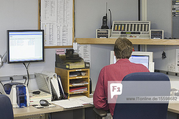 Rear view of a man working in a control room