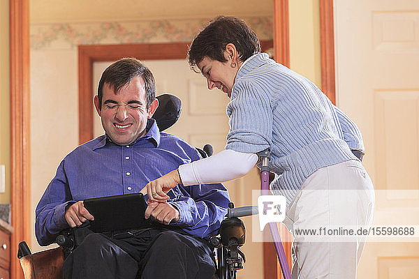 Couple with Cerebral Palsy looking at their tablet