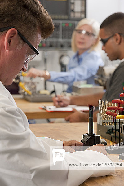 Ingenieurprofessor beim Einsetzen einer CNC-Werkzeugmaschine in den Werkzeughalter