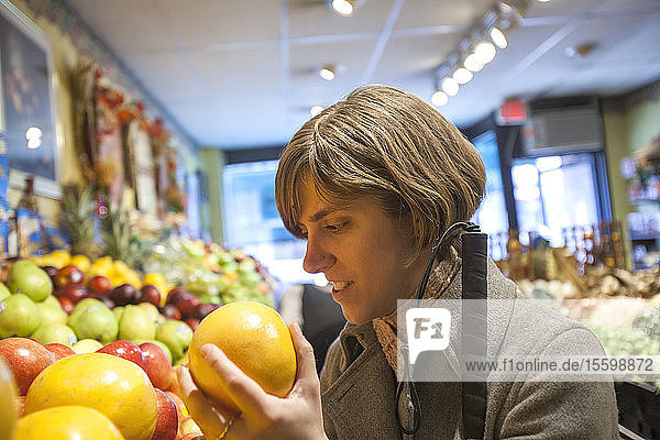 Junge blinde Frau beim Einkaufen von Obst in einem Lebensmittelgeschäft