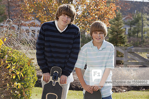 Zwei Brüder stehen mit Skateboards