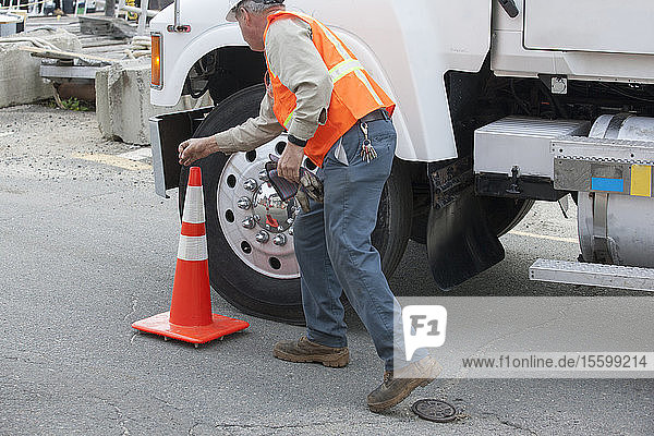 Environmental engineer removing traffic cone at tanker truck for hazardous waste cleanup