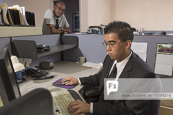 Zwei Männer mit Autismus arbeiten am Computer in einem Büro