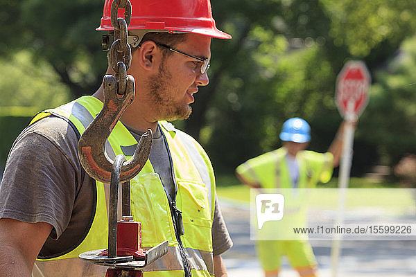 Construction worker moving gate valve on street