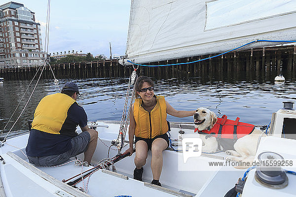 Ehepaar mit Sehbehinderung und Diensthund auf einem Segelboot