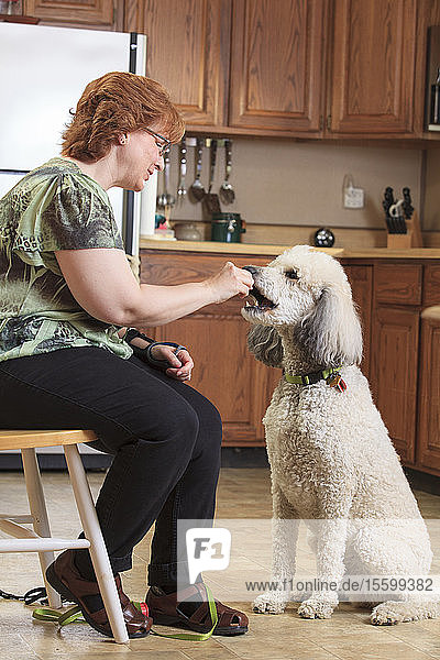 Frau mit RSD füttert ihren Diensthund