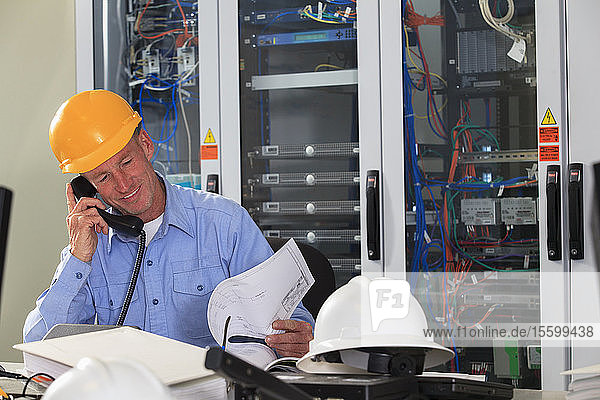 Electrical engineer reviewing process diagrams in operations room of electric power plant