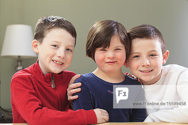 Kleines Mädchen mit Down-Syndrom spielt mit ihren Brüdern