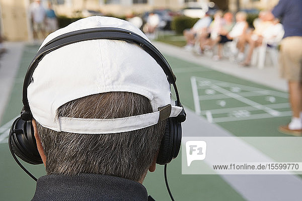 Rückansicht eines älteren Mannes mit Kopfhörern