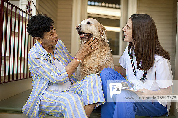 Woman sitting on the stairs with her dog and nurse.