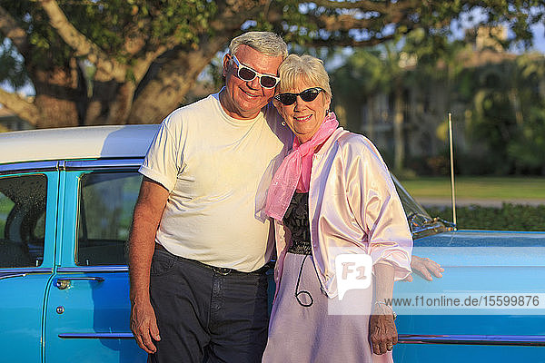 Porträt eines glücklichen älteren Paares vor einem Auto